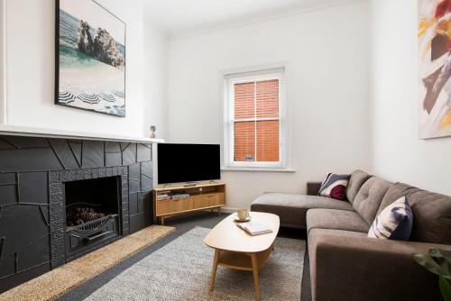 a living room with a couch and a fireplace at Salty Pines - 3BR House Glenelg South in Glenelg