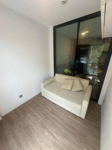 a white couch in a room with a window at Great Value Apartment in Bang Khen