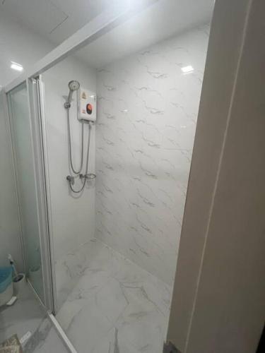 a bathroom with a shower with white marble tiles at Great Value Apartment in Bang Khen