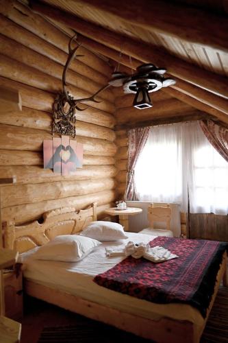 a bedroom with a bed in a wooden wall at Pensiunea Laricea in Vatra Dornei