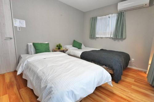 two beds in a room with green and white sheets at ZJ301 Hanama301 The Skytree Residence A Newly Home by Tokyo Iconic Landmarks in Tokyo