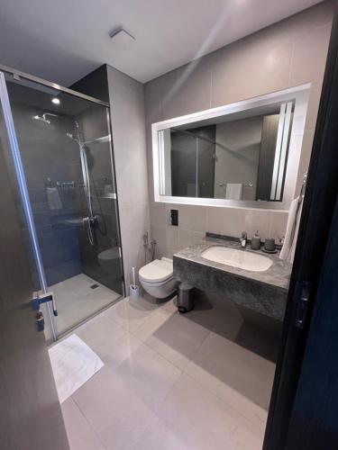 a bathroom with a shower and a sink and a toilet at Cozy Stay in Manama