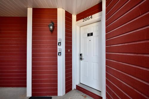 a red house with a white door and a sign that reads moth at Jacuzzi Suite with King bed, full kitchen in Shanty Bay