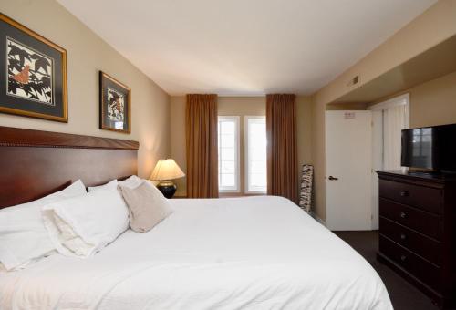 a bedroom with a white bed and a television at Jacuzzi Suite with King bed, full kitchen in Shanty Bay