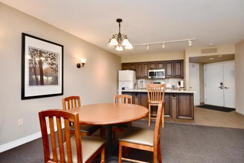 a kitchen and dining room with a table and chairs at Jacuzzi Suite with King bed, full kitchen in Shanty Bay