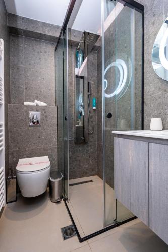 a bathroom with a shower and a toilet and a sink at Empress Luxury Residences in Volos