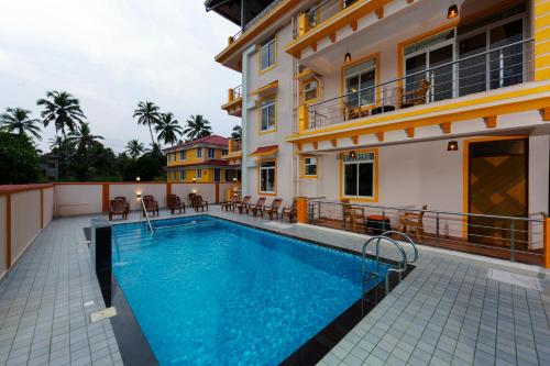 a swimming pool in front of a building at Lykke Suites- 2-min Drive to Colva Beach-By Goan Felicidade Hospitality PVT LTD in Colva