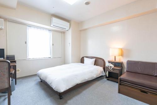 a bedroom with a bed and a couch and a window at Hotel Alpha Inn Akita - Vacation STAY 67278v in Akita