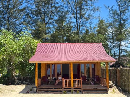 a small house with a red roof at Simagirau Homestay in Simpatdegat