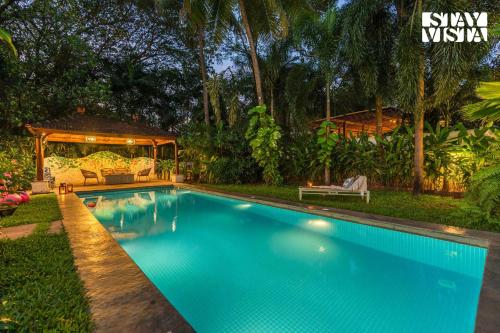 a swimming pool in a backyard with a gazebo at StayVista at A Portuguese Tale - Pool, Bar & BBQ in Assagao