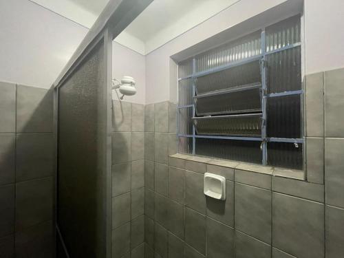 a bathroom with a shower with a toilet paper holder at Hotel Palace Econômico in Goiânia