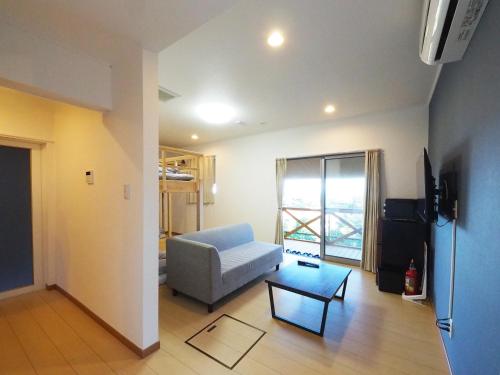 a living room with a couch and a table at locona +rakuta in Hyuga