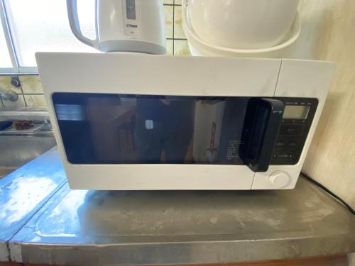 a white microwave sitting on top of a counter at 百代家 養老 飯ノ木 in Yoro