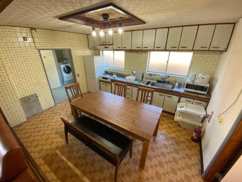 a kitchen with a wooden table and a dining room at 百代家 養老 飯ノ木 in Yoro