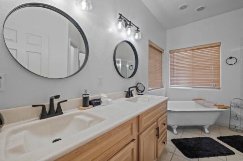 a bathroom with two sinks and a tub and a mirror at Zen Whisper in the Woods in Groveland