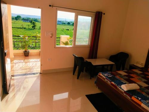 une chambre avec un lit, une table et une fenêtre dans l'établissement Airport Luxury Nature Homestay- Near Jolly Grant Airport Dehradun, à Doiwāla