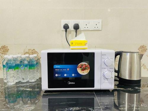 a white microwave sitting on top of a counter at Cozy Kulai Retreat 5Min AeonPalm Resort15Min Senai airport in Kulai