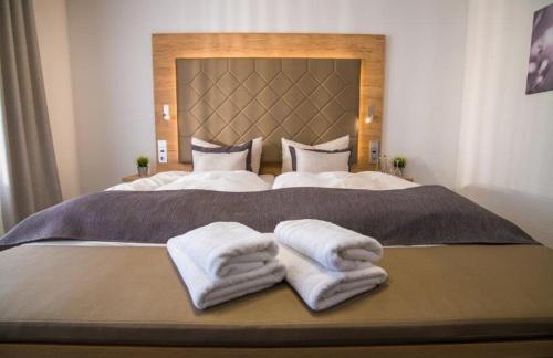 a bedroom with a large bed with towels on it at Hagen`s Hotel "eat & meet" Restaurant Bar Lounge in Haren