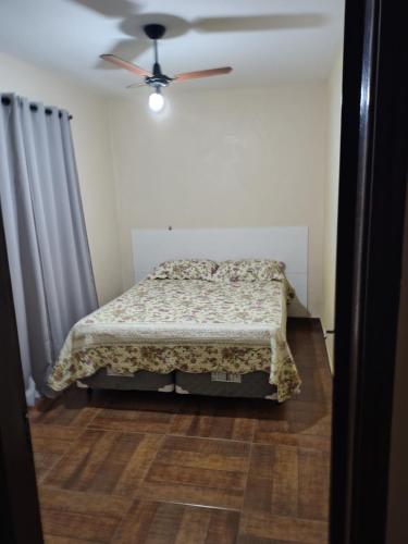 a bedroom with a bed and a ceiling fan at Casa DIMAS in São Pedro