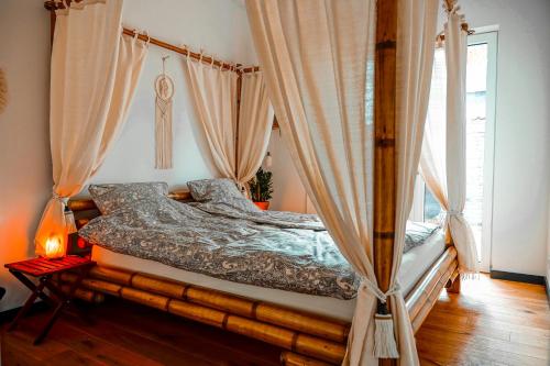 a bedroom with a canopy bed with curtains at Urban Jungle Room rundum Entspannung mit Sauna in Troisdorf