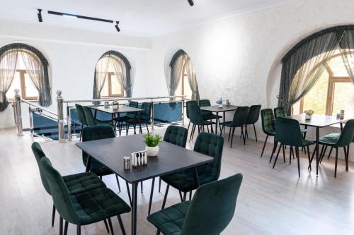 a dining room with tables and chairs and windows at Status Inn Hotel in Samarkand