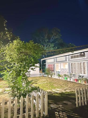 a white fence in front of a building at Sunny Villa in Sivasagar