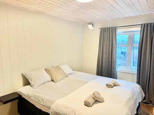 a bedroom with a bed with two slippers on it at Villa in central Narvik! in Narvik