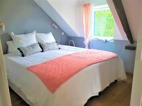 a bedroom with a large bed with a window at Le Clos du Palastre, à 10 mn de Vannes in Plescop