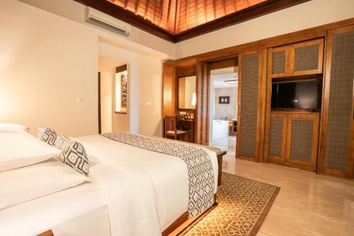 a bedroom with two beds and a flat screen tv at Ramayana Suites and Resort in Kuta