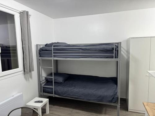 une chambre avec deux lits superposés et une fenêtre dans l'établissement Appartement I, RESIDENCE DU RENOUVEAU, Stade de France, idéal pour 2 pers, à Saint-Denis