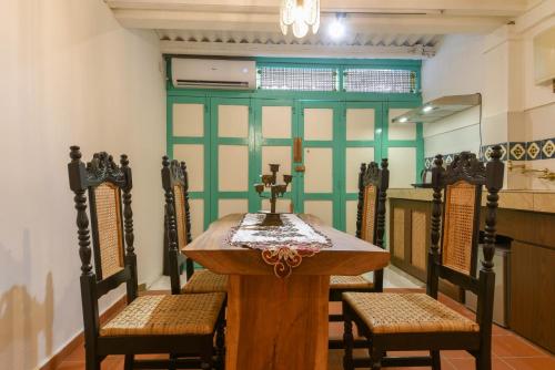 a dining room table with chairs and a cross on it at Ohana House-H3 in Melaka