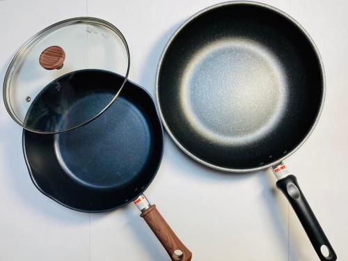 eine Bratpfanne und eine Bratpfanne mit Schneebesen in der Unterkunft ぷらむならまち Momiji邸 in Nara