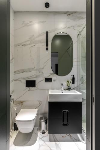 a bathroom with a toilet and a sink and a mirror at Old City apart in Lviv