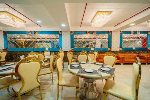 a dining room with tables and chairs and blue walls at Treebo Marigold in New Delhi