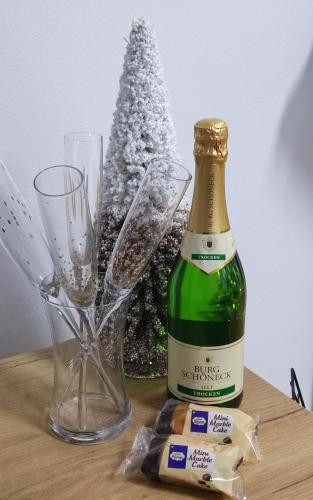 a bottle of wine and two glasses and a christmas tree at City011 in Belgrade