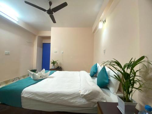 a bedroom with a large white bed with blue pillows at Hotel Resunga Arjun in Kathmandu