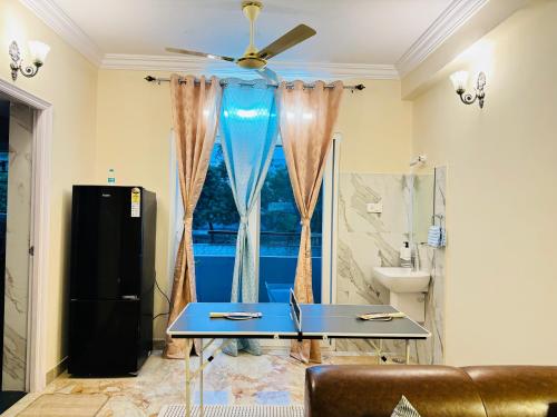 a living room with a table and a window at Elegant 3BHK Fully Furnished and Equipped Apt near Hitec City by EVARA SUITES in Hyderabad