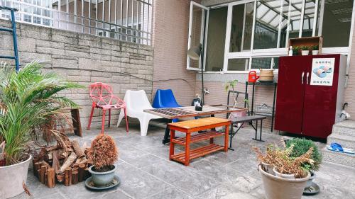 a patio with a table and chairs and plants at 東海獨角獸 in Longjing