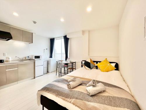 a bedroom with a large bed with two towels on it at 君の家AOTO#Haneda&Narita Access#Free reserved parking in Tokyo