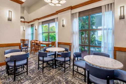 a waiting room with tables and chairs and windows at Hyatt Place Mystic in Mystic