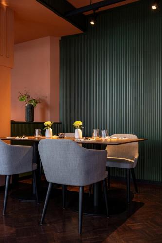 a dining room with tables and chairs and a green wall at Studio 9 in Fulda