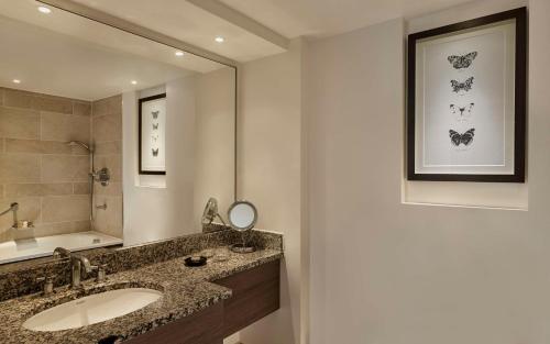 a bathroom with a sink and a mirror at Hyatt Regency London - The Churchill in London