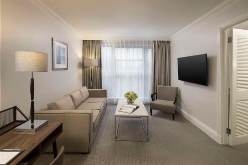 a living room with a couch and a table at Hyatt Regency London - The Churchill in London