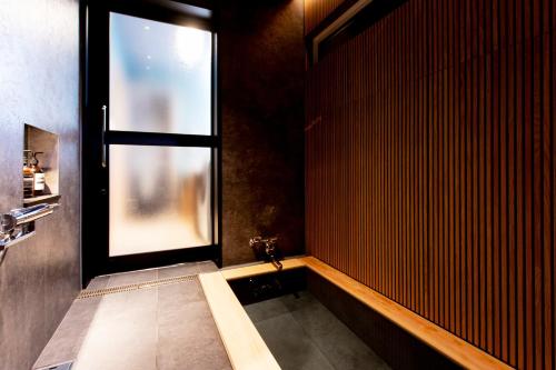 a bathroom with a large window in a room at 貸し切り宿 世紡 YOTSUMUGI sakazuki and iyasaka in Yufuin