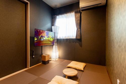 a small living room with a couch and a window at 貸し切り宿 世紡 YOTSUMUGI sakazuki and iyasaka in Yufuin