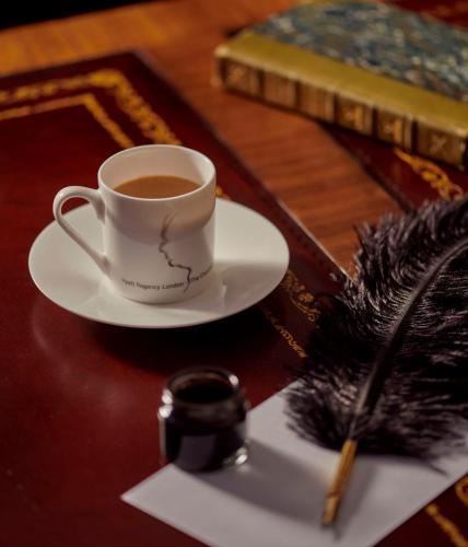 a cup of coffee on a plate on a table at Hyatt Regency London - The Churchill in London