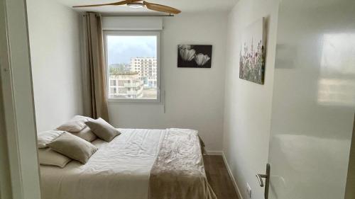 une chambre avec un lit avec une fenêtre dans l'établissement Au Bord'eaux de Malou, à Bordeaux