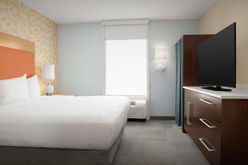 a bedroom with a bed and a flat screen tv at Home2 Suites by Hilton Baltimore/White Marsh in White Marsh