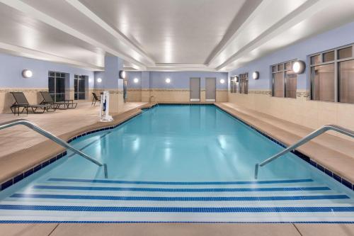 a swimming pool with blue water in a building at Hampton Inn & Suites Saginaw in Saginaw