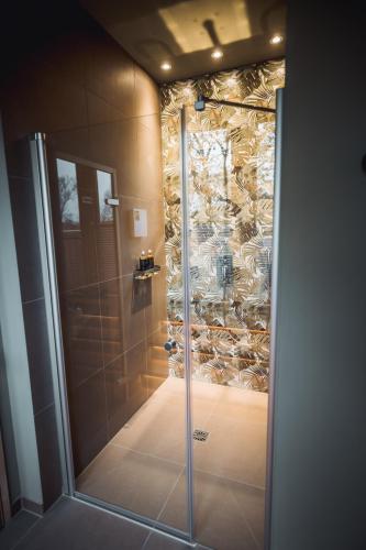 a shower with a glass door in a bathroom at Hotel Ederstrand in Frankenberg